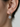 Side view of a hoop earring showing the hinged lever-back fastening and suspended zirconia drop.