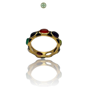 A gold-colored eternity ring with multiple colored gemstones set in black enamel, displayed on a reflective surface.