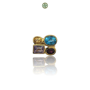 A gold vermeil ring with multiple gemstones including blue topaz, amethyst, citrine, and garnet arranged in an asymmetric design.