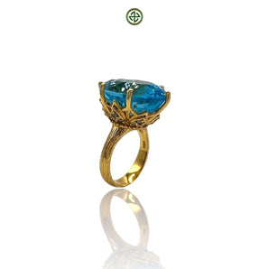 A blue topaz ring with aqua marines on the sides, set in a gold vermeil band