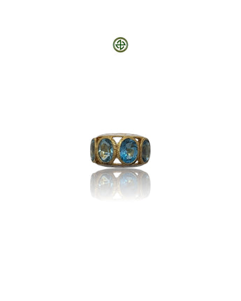A ring with blue topaz stones set in a gold vermeil band with enamel finish.
