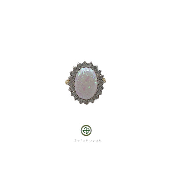 An opal and zirconia ring with a silver setting and 18ct yellow gold plating, featuring a cluster of zirconias around the opal.