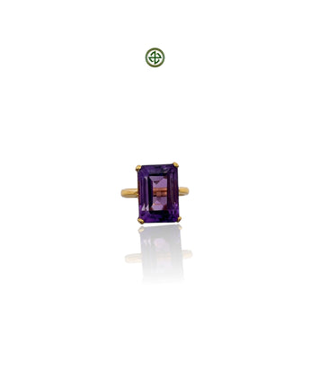 An emerald cut amethyst ring with a gold vermeil band on a white background.