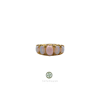 An opal ring with gold vermeil plating on a silver base, featuring a central opal stone surrounded by smaller clear crystals set in a gold-colored band.