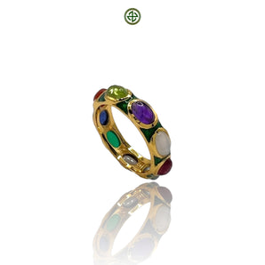 A gold vermeil eternity ring with multiple gemstones set in a green enamel band, displayed on a reflective surface.