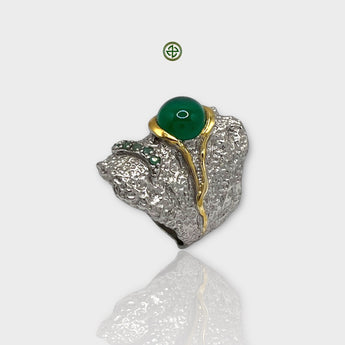 A silver ring featuring a central green onyx gemstone with gold vermeil detailing and flanked by smaller emerald stones.