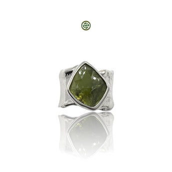 A green tourmaline gemstone set in a sterling silver ring with a white rhodium finish.