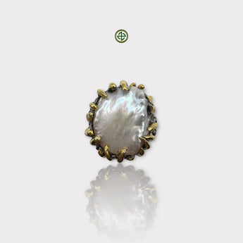 A large baroque pearl ring with a gold and silver textured band, displayed against a white background.