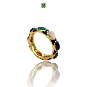A navy blue enamel eternity ring with gold vermeil and multiple gemstones set within the band.