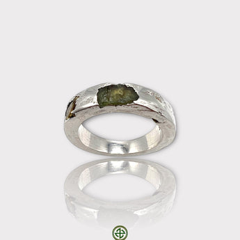 A silver ring featuring a raw peridot and yellow tourmaline gemstone, with a white rhodium plating.