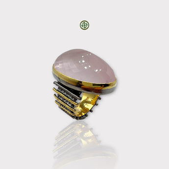 A rose quartz statement ring with a gold and black rhodium plating, displayed against a white background.