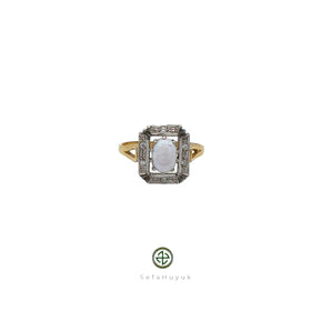 A ring with a central opal stone surrounded by baguette cut zirconias, with yellow gold plating on silver.