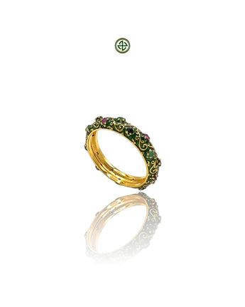 A Stucky-style eternity ring with green enamel and a band of ruby, emerald, and sapphire stones set in a gold vermeil band.