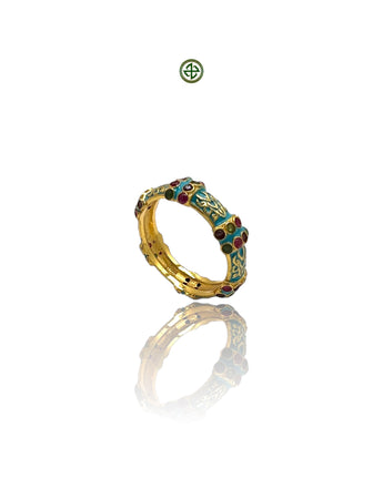 A gold vermeil ring with turquoise enamel and inlaid stones, displayed against a reflective background.