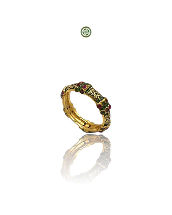 A gold-colored eternity ring with green enamel and alternating ruby, emerald, and amethyst stones set around its band.