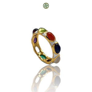 A multicolored gemstone ring with a gold band and white enamel detailing, featuring a variety of gemstones including amethyst, ruby, and sapphire.