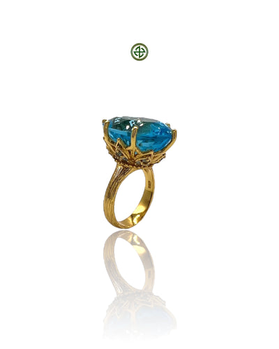 A blue topaz ring with aqua marines on the sides, set in a gold vermeil band