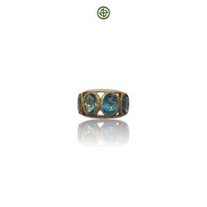 A ring with blue topaz stones set in a gold vermeil band with enamel finish.