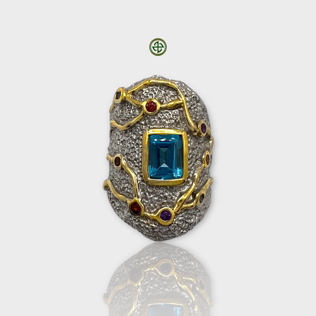 A detailed image of a Blue Topaz natural stone ring with gold and silver plating, featuring multiple colored gemstones.