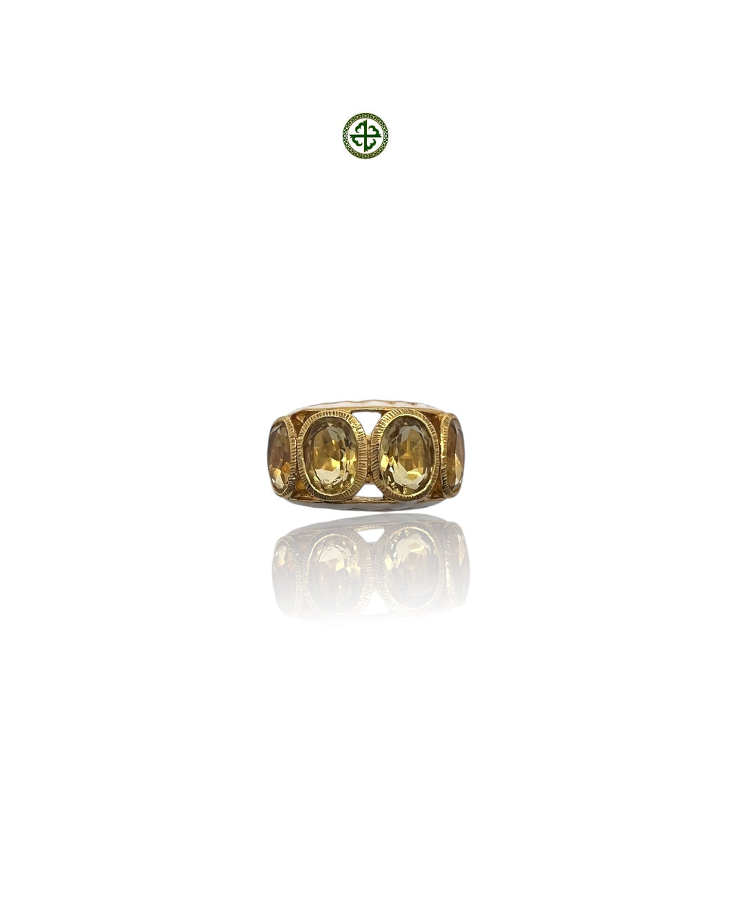 A gold-colored ring with four citrine stones arranged in a line, set against a white background.