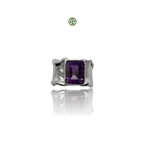 A cushion cut purple amethyst quartz gemstone set in a silver ring with a white rhodium finish.