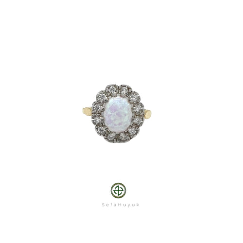 An 18ct gold vermeil on silver ring with a central opal stone and surrounding zirconia embellishments.