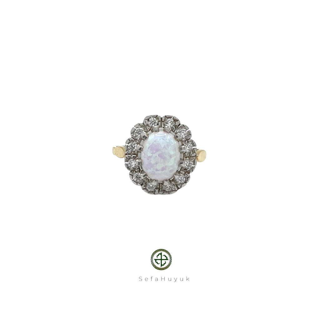 An 18ct gold vermeil on silver ring with a central opal stone and surrounding zirconia embellishments.