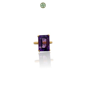 An emerald cut amethyst ring with a gold vermeil band on a white background.