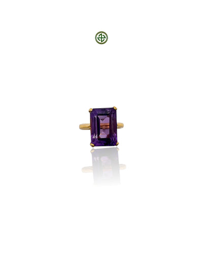 An emerald cut amethyst ring with a gold vermeil band on a white background.