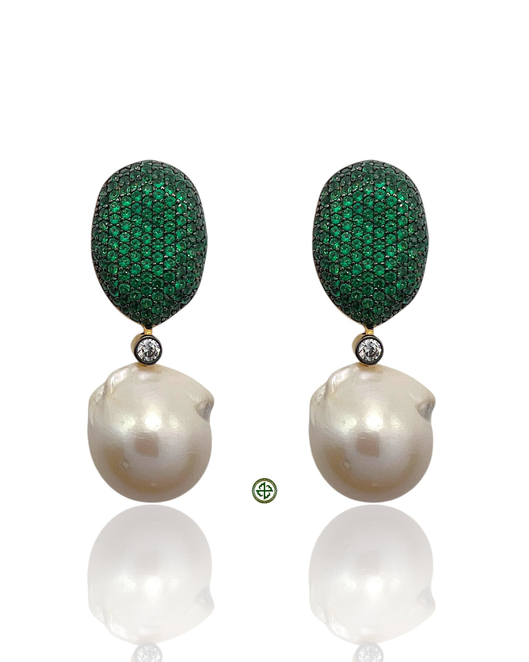 Pair of earrings with green gemstone drops and pearl-like bases on a white background