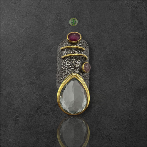 A silver ring featuring a green amethyst, a ruby, and a pink tourmaline gemstone, with gold vermeil detailing.