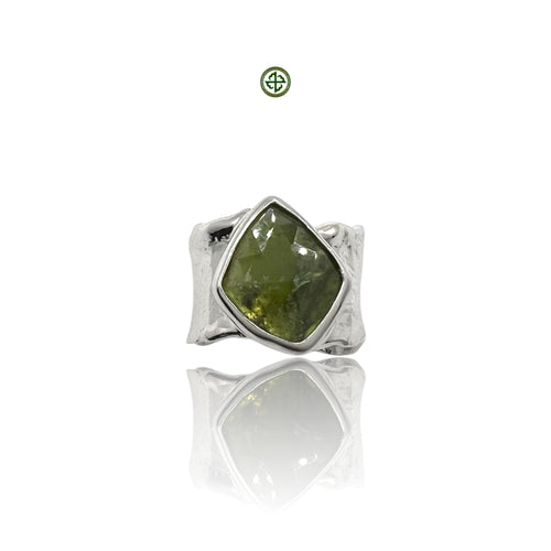 A green tourmaline gemstone set in a sterling silver ring with a white rhodium finish.