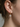 Hoop earrings beside their detached round zirconia drops, showing the removable charm design.