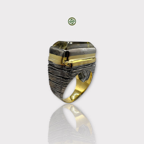 A Lemon Quartz ring with a silver band and gold vermeil details, showcasing a large, yellowish quartz stone set in a textured mounting.