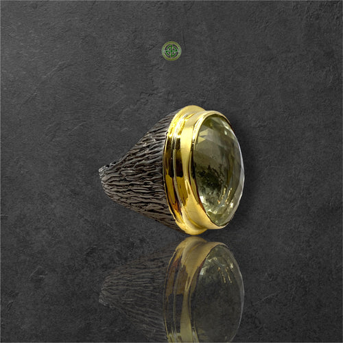 A Lemon Quartz ring with a gold vermeil and rhodium plating on a silver band, displayed on a dark background.