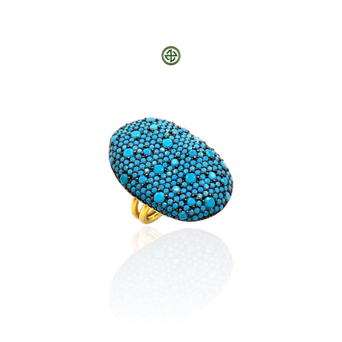 A gold vermeil ring with a pave set of turquoise stones on a white background.
