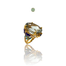 An elegant Natural Oval Green Amethyst Ring with gold vermeil plating and multicolored enamel accents on a silver band, displayed against a white background.