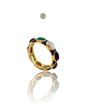 A navy blue enamel eternity ring with gold vermeil and multiple gemstones set within the band.