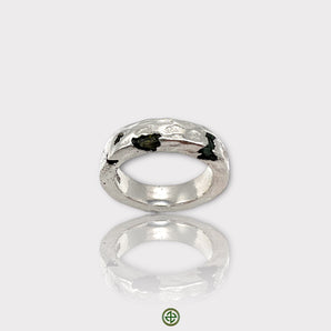 A silver band ring featuring a raw black tourmaline gemstone, with a visible textured finish on the metal.