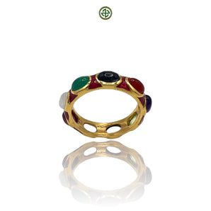 A gold-colored eternity ring with multiple colorful gemstones and red enamel accents, displayed against a white background.
