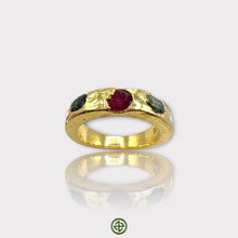 A gold-colored band ring featuring a central ruby with green tourmaline on either side, set in a textured setting.