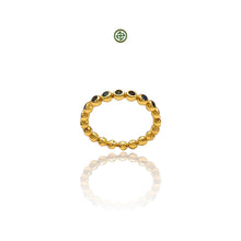 A gold-colored stacking band ring with sapphire stones set in a pattern around its circumference.