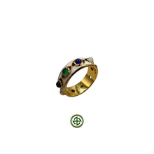 A gold-colored ring featuring a series of multicolored gemstones set in a Barrel ring design with white enamel accents.