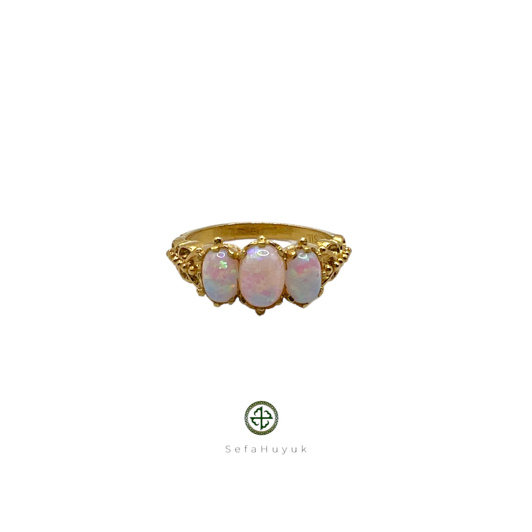 A Smilla Opal ring with a central opal stone surrounded by smaller opal inlays, set in a gold vermeil on silver base.