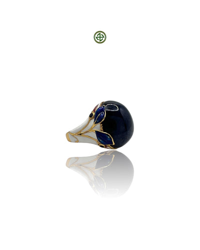 An enamel statement ring featuring a star sapphire center stone with gold vermeil plating and blue, red, and white enamel details.