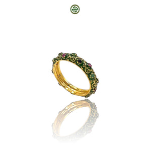 A Stucky-style eternity ring with green enamel and a band of ruby, emerald, and sapphire stones set in a gold vermeil band.