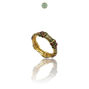 A gold-colored eternity ring with green enamel and alternating ruby, emerald, and amethyst stones set around its band.
