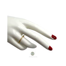 A slim band ring with a round cut zirconia gem, set in a gold or silver plating.