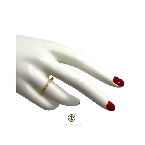 A slim band ring with a round cut zirconia gem, set in a gold or silver plating.