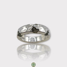 A silver ring featuring a raw peridot gemstone with a textured band.